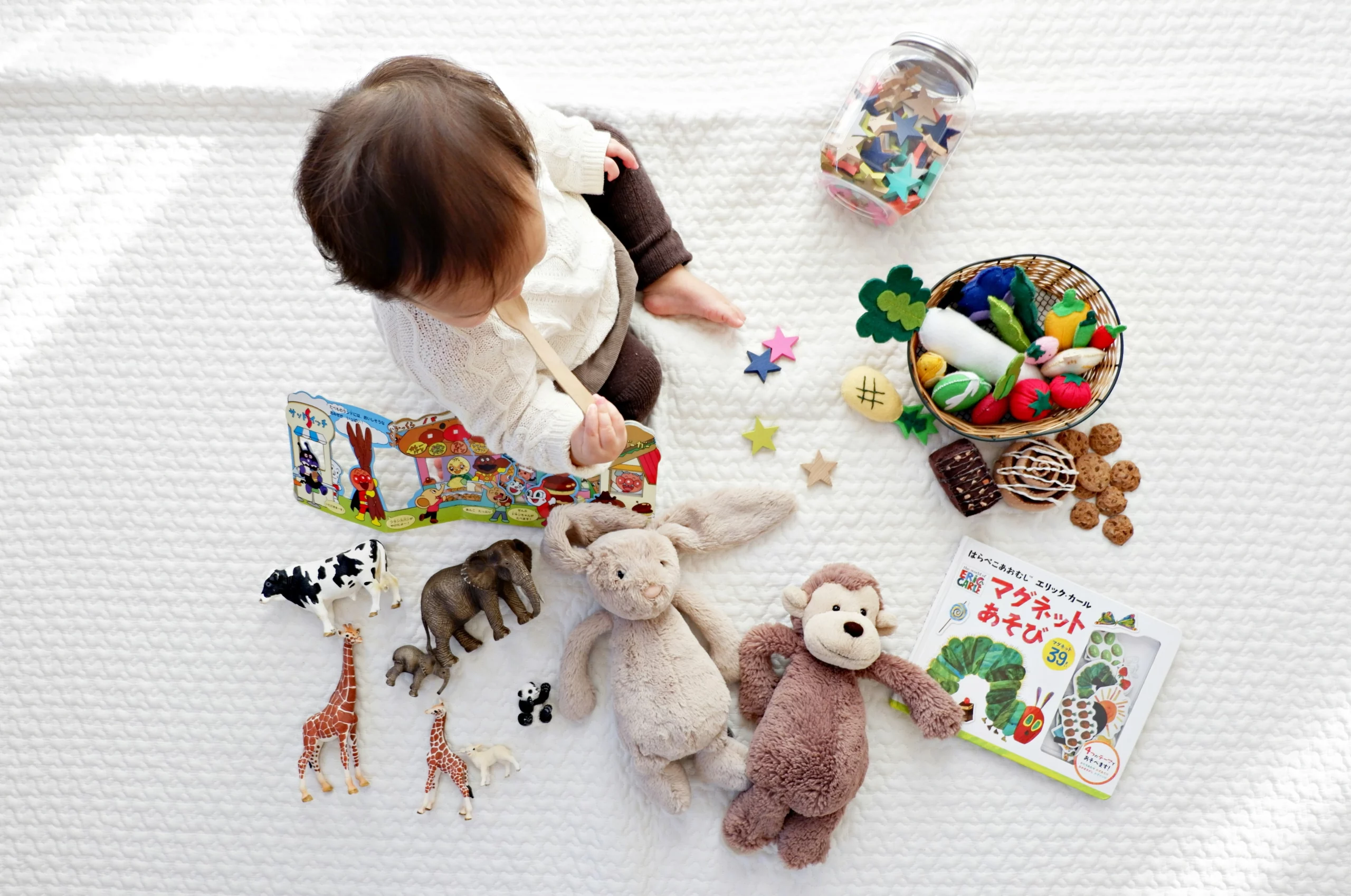 Jouets avec des couleurs, peluches lapin, singe, animaux : girafe, vache, éléphant, livre en tissus