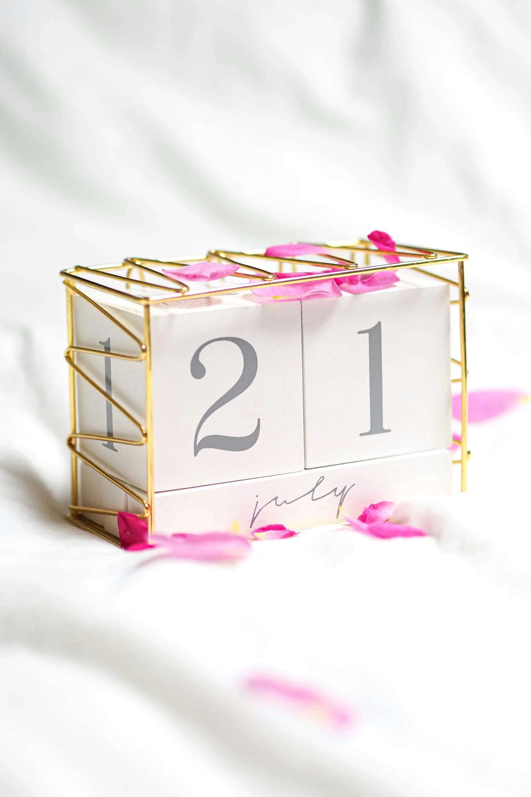 Cube doré avec le chiffre 21 représentant une date et de la couleur rose pastel